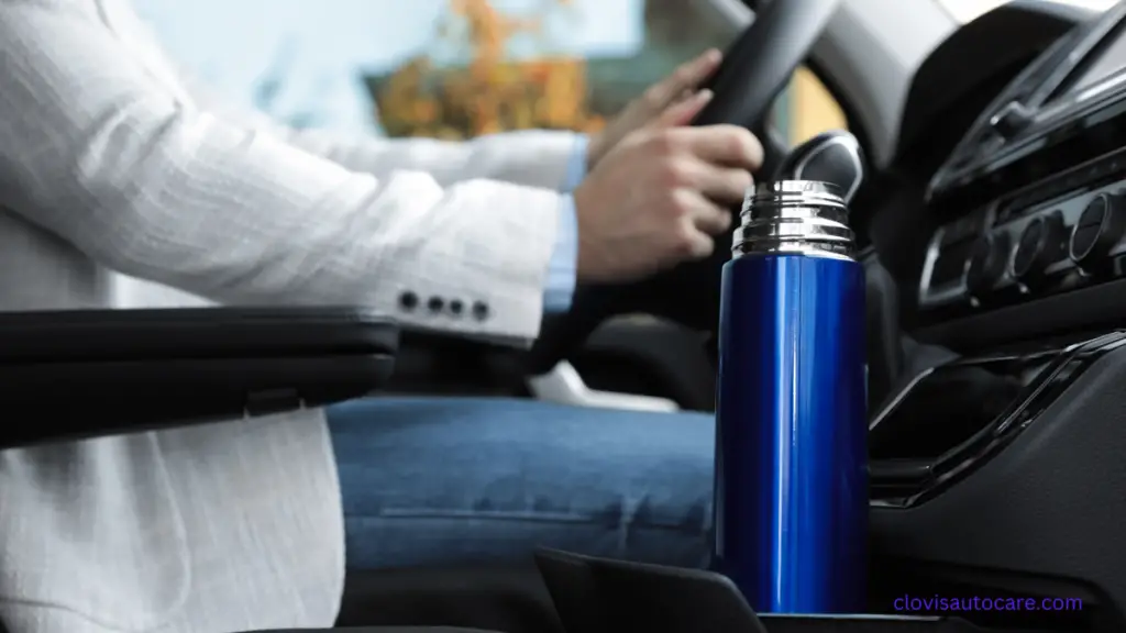 a blue little container of coffee in a cup holder inside a car