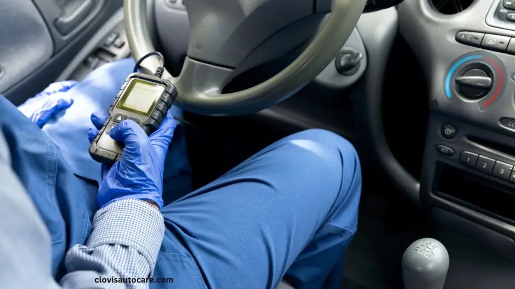 a man on blue using a car scanner to check car faults