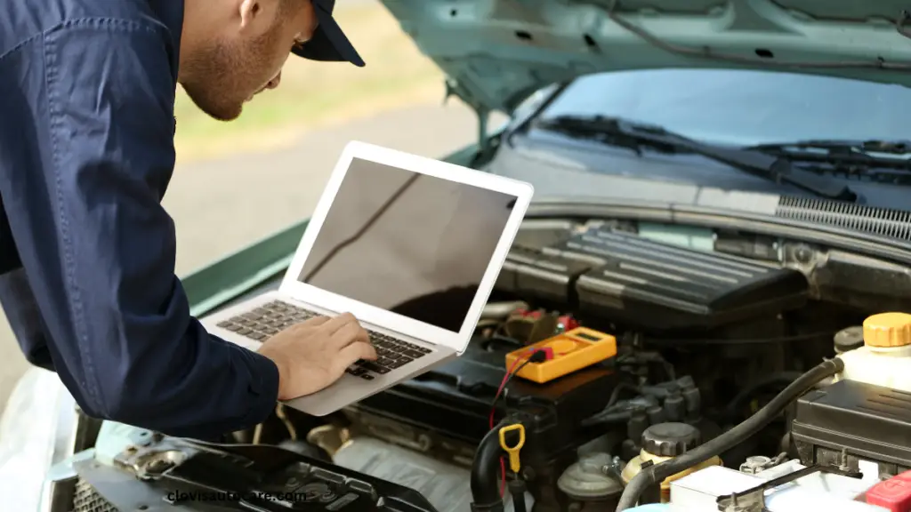 topdon scan tool. a man with his laptop in front of an open hood of a car diagnosing faults codes