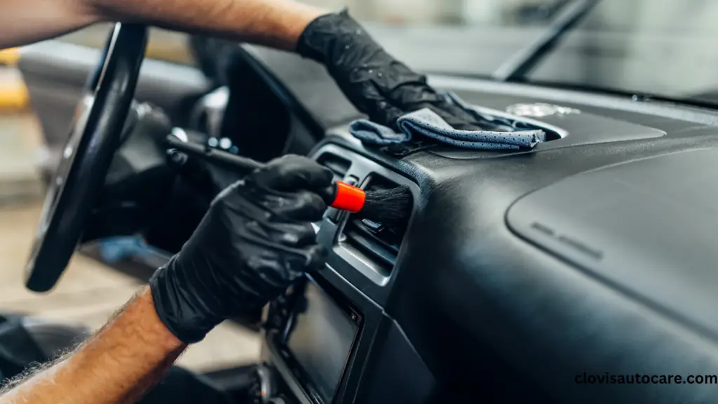 a person putting on black hand gloves using a brush to clean car vents clean car aesthetics