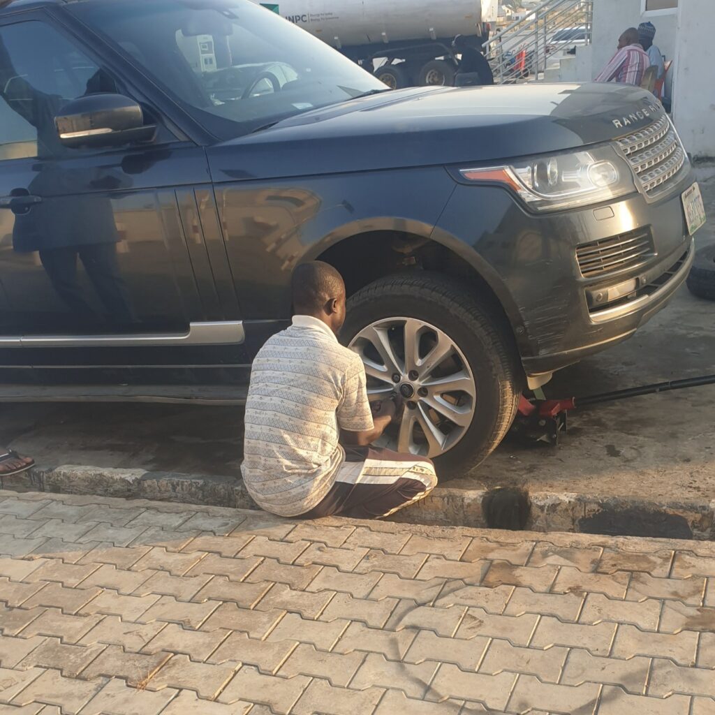 a mechanic changing a car tire. car repair in Nigeria