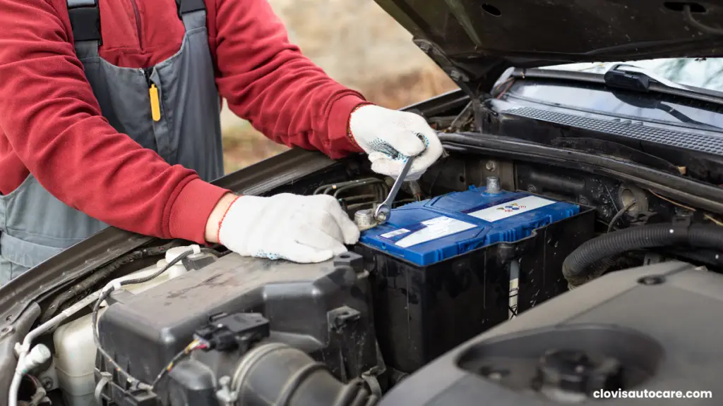 A man with hand gloves is removing a battery terminal clamp. how to repair a car battery