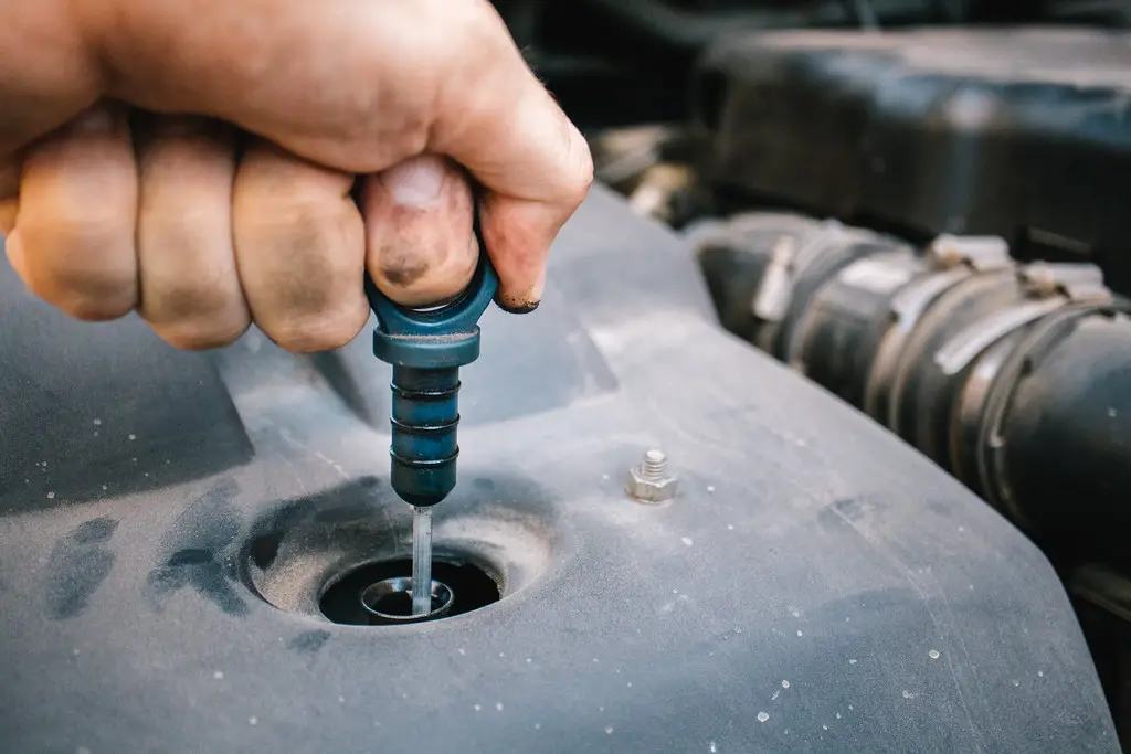 checking engine oil level with dipstick